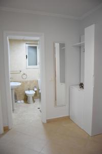 a white bathroom with a sink and a toilet at Click Apartments - Tirana in Tirana