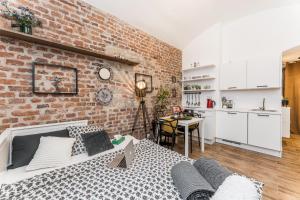 a room with a brick wall and a bed and a kitchen at Apartmán u Stromovky nedaleko centra in Prague