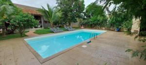 een groot zwembad met twee stoelen en een huis bij Villa la Linguère in Somone