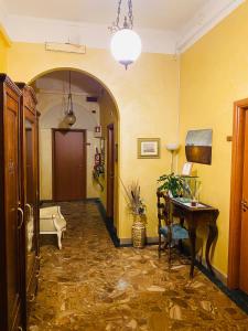 un couloir avec une table et des murs jaunes dans l'établissement Hotel Ferrucci, à Turin