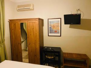 a room with a cabinet and a television on the wall at Hotel Ferrucci in Turin