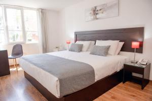 a bedroom with a large bed and a desk with a phone at Hoteles Riviera Ejecutivo in Arequipa +30 photos