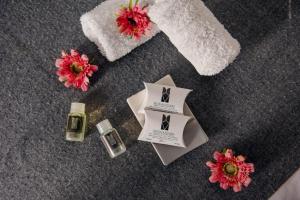 a table with flowers and a bottle of perfume at Hoteles Riviera Colonial in Arequipa