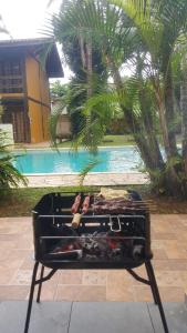 a suitcase sitting on a stand in front of a pool at Vila da Praia in Boicucanga