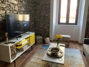 een woonkamer met een televisie en een tafel bij Techas City Center Luxurious Studio in Praia