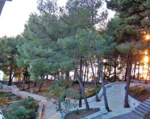 un parco con alberi e cespugli e un marciapiede di Apartments Lavica a Podstrana