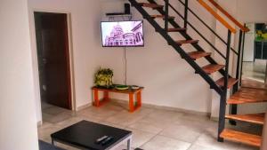 sala de estar con escalera y TV en la pared en Terracita Palermo en Buenos Aires