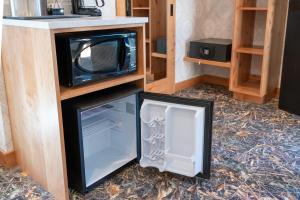 a microwave and a refrigerator in a room at The Dorothy Motel in Banff