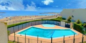 una imagen de una piscina junto a una playa en Logement entier vue sur mer !, en Palavas-les-Flots
