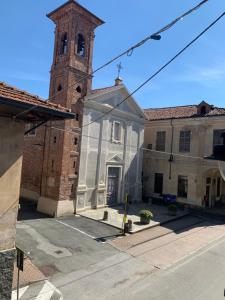 een kerk met een klokkentoren in een straat bij Alloggio Berenice in Villafranca Piemonte
