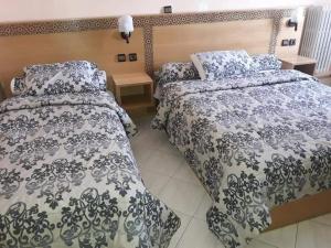 ラバトにあるHOTEL VELLEDAのベッドルーム1室(ベッド2台、ベッドスカート付) +9枚の写真