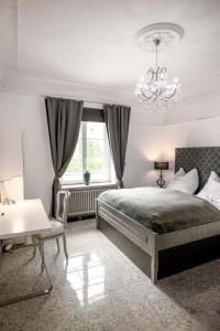 1 dormitorio con cama y lámpara de araña en Villa Vera, en Wetter