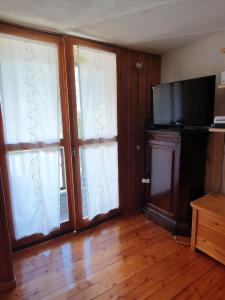 a living room with two sliding doors and a flat screen tv at Il Rifugio di Marcella in Challand Saint Anselme