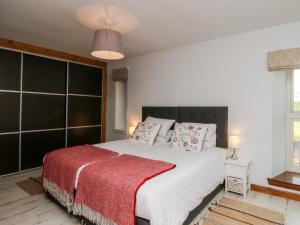 um quarto com uma cama grande e um cobertor vermelho em Camisky Steading em Fort William