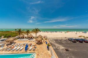 a view of a beach with a pool and chairs and umbrellas at 207 Beach Place Condos in St Pete Beach