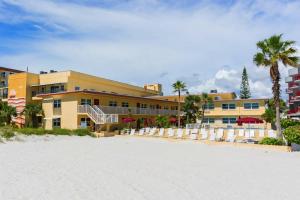 un complejo en la playa con sillas y palmeras en 227 Surf Song Resort, en St Pete Beach