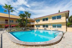 a swimming pool in front of a building at 239 Surf Song Resort in St. Pete Beach