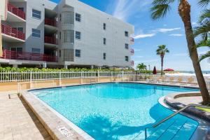 a swimming pool in front of a building at 239 Surf Song Resort in St. Pete Beach