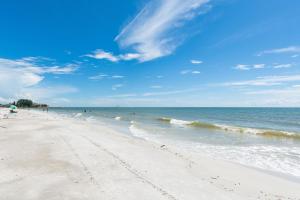 a beach with people swimming in the ocean at 239 Surf Song Resort in St. Pete Beach