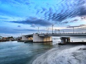 a bridge over the water next to a beach at 239 Surf Song Resort in St. Pete Beach