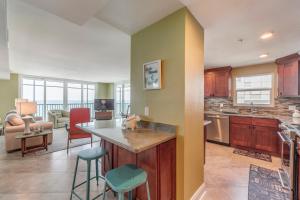 a kitchen and living room with a counter and chairs at #505 Shores of Madeira in St. Pete Beach