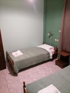 a bedroom with two beds and a table with towels at Guesthouse Chotos in Samarina
