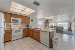 a kitchen with wooden cabinets and white appliances at 204 Beach Place Condos in St Pete Beach