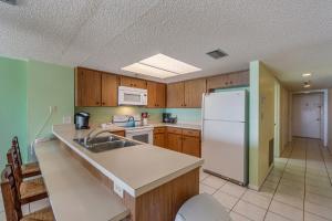 uma cozinha com um lavatório e um frigorífico branco em 407 Beach Place Condos em St. Pete Beach