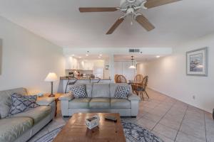 a living room with a couch and a ceiling fan at 403 The Shores Condo in St. Pete Beach