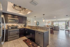 a kitchen with stainless steel appliances and a living room at 102 Beach Place Condos in St. Pete Beach