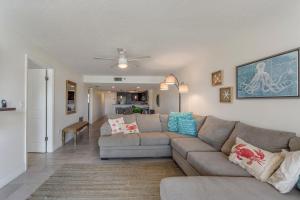 a living room with a couch and a ceiling fan at 102 Beach Place Condos in St. Pete Beach