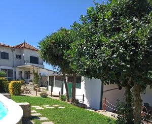 a house with a yard with trees and a swimming pool at Casa da Belavista in Trofa