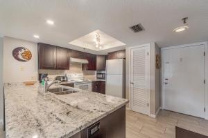 cocina con encimera de granito y fregadero en 101 Beach Place Condos, en St Pete Beach