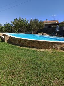 uma piscina com uma parede de pedra à volta em Casa da Belavista em Trofa