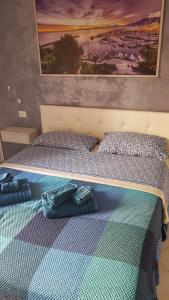 a bedroom with two beds and a painting on the wall at B&B Del Corso in Cefalù