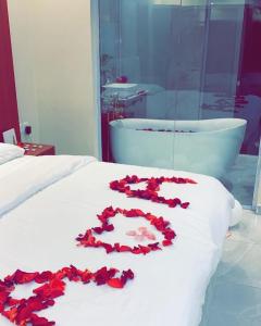 a bunch of red roses on a bed with a bath tub at Sydra Chalet in Riyadh