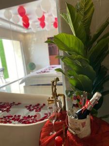 a bath tub with a plant and a glass of wine at Sydra Chalet in Riyadh