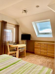 a bedroom with a bed and a table and a window at Haag Ferienwohnungen von "Small" bis "XL" für max 10 Personen und 6 Schlafzimmern in Aalen