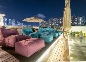 a row of blue and pink couches on a rooftop at Hotel Hyggelig in Busan