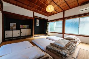 two beds sitting in a room with windows at Momonga Village in Miyoshi