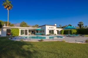 une maison avec une piscine dans la cour dans l'établissement Casa Agave Palm Springs, à Palm Springs