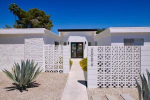 une clôture blanche devant une maison blanche dans l'établissement Casa Agave Palm Springs, à Palm Springs