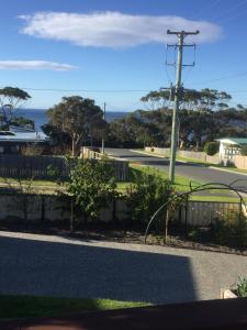 a view of a street with a fence and the ocean at Wheel House Studio in Bicheno