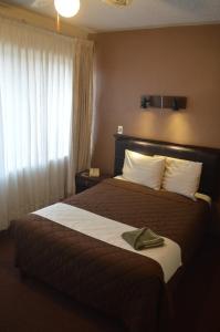 a hotel room with a bed with a hat on it at Hotel Flamingo Kristal in Irapuato