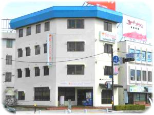 盐尻市Biz Hotel Shiojiri Ekimae的一座蓝色屋顶的白色大楼
