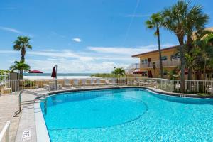 a swimming pool with a view of the ocean at 346 Surf Song Resort in St Pete Beach