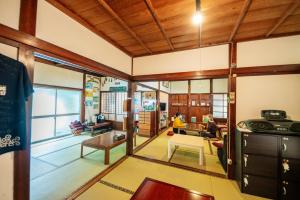 a living room with wooden ceilings and a large window at Momonga Village in Miyoshi