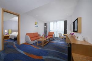 um quarto de hotel com um sofá e uma sala de estar em Holiday Inn Express Zhengzhou Zhengdong, an IHG Hotel em Zhengzhou