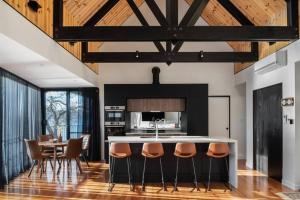 a kitchen with a bar with chairs and a table at Deviot Boat House in Deviot