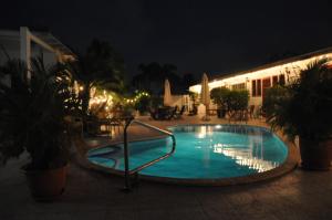 a swimming pool at night in a courtyard at Palmita Hostel Chez Harmony in Oranjestad